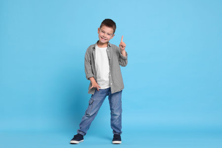 Cute little boy on light blue backgroundの写真素材