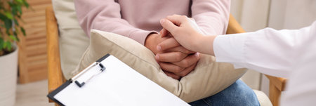 Professional psychologist supporting patient during therapy in office, closeupの写真素材