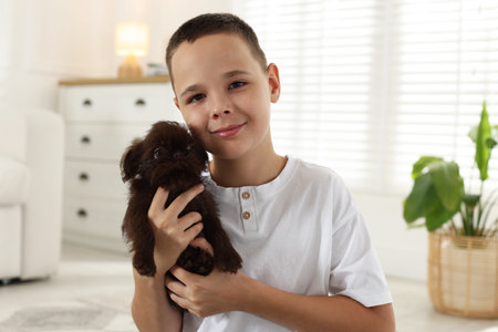 Child with cute Griffon puppy at home. Domestic pet