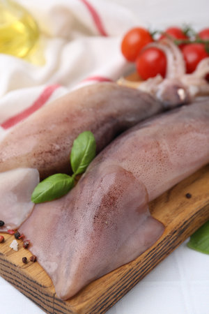 Fresh raw squids, tomatoes and spices on white table, closeupの写真素材
