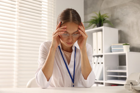 Tired nurse at table in clinic. Medical workerの写真素材