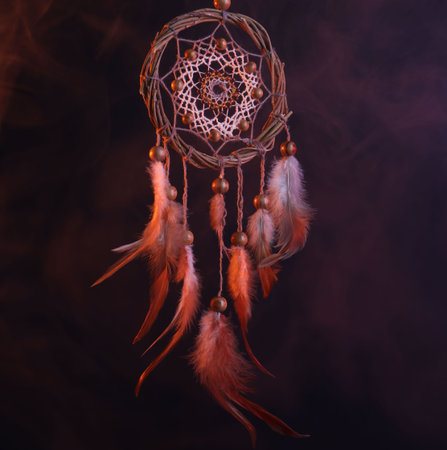 Beautiful dream catcher in color lights on dark backgroundの写真素材