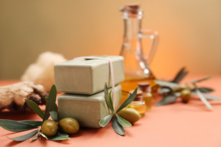 Handmade soap bars, olive, green leaves and oil on color background, closeupの写真素材