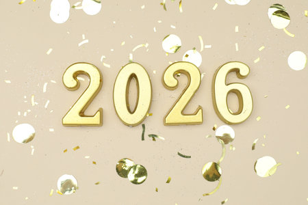 New 2026 Year. Golden numbers and confetti on beige background, flat layの写真素材