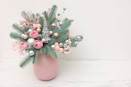 Beautiful composition with fir tree branches in vase on light marble table near white wall indoors, space for text. Winter decorの写真素材
