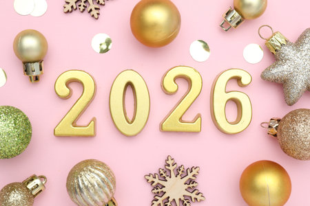 New 2026 Year. Golden numbers, shiny baubles and wooden snowflakes on pink background, flat layの写真素材