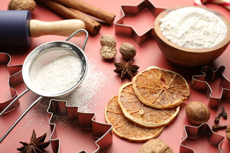 Christmas composition with cookie cutters, spices and flour on red background, closeupの写真素材