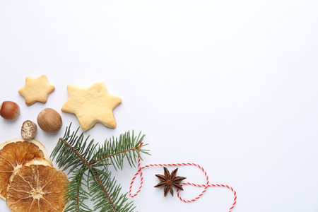 Christmas composition with fir tree branches, cookies and spices on white background, flat lay. Space for textの写真素材