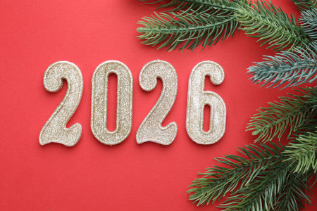 New Year. Golden making numbers 2026 and decorative fir branches on red background, flat layの写真素材