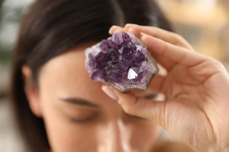 Woman meditating with crystal to heal or restore her aura indoors, closeupの写真素材