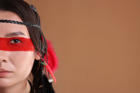 Shaman woman with face painting on pale brown background, closeup. Space for textの写真素材