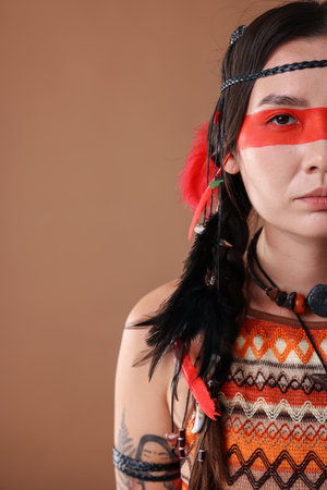 Shaman woman with face painting on pale brown background, closeup. Space for textの写真素材