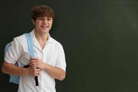 Back to school. Student with backpack near chalkboard indoors, space for textの写真素材