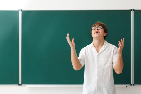 Back to school. Emotional boy near chalkboard indoors, space for textの写真素材
