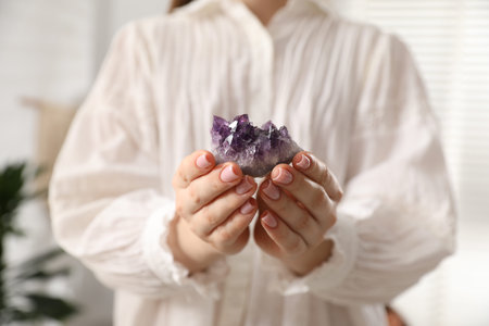 Woman meditating with crystal to heal or restore her aura indoors, closeupの写真素材