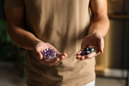 Man meditating with crystal to heal or restore his aura indoors, closeupの写真素材