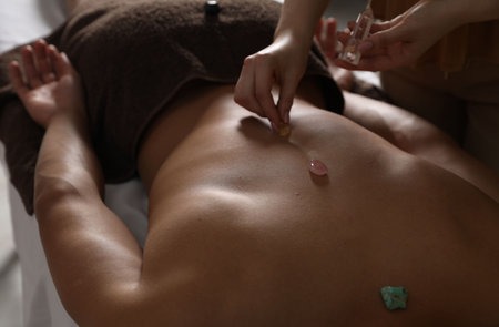 Man undergoing crystal therapy to heal or restore his aura indoors, closeupの写真素材