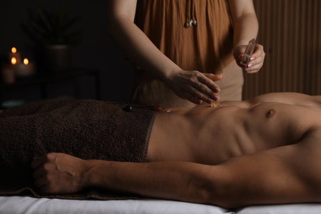 Man undergoing crystal therapy to heal or restore his aura indoors, closeupの写真素材