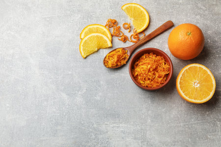 Orange zest and fresh fruits on light gray table, flat lay. Space for textの写真素材