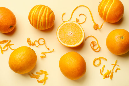 Orange zest and fresh fruits on beige background, flat lay