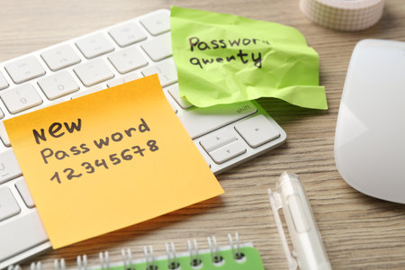 Changing password. Paper notes with new and old passwords, stationery and keyboard on wooden table, closeupの写真素材