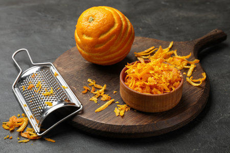 Orange zest, fresh fruit and grater on black table, closeupの写真素材