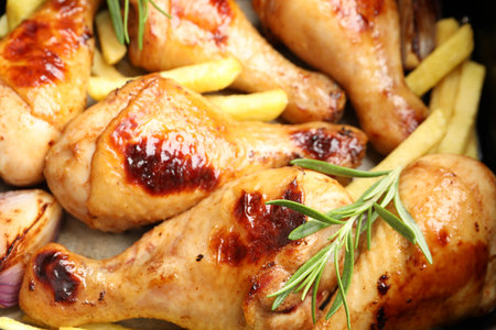 Grilled chicken drumsticks, French fries and spices in air fryer basket, closeupの写真素材