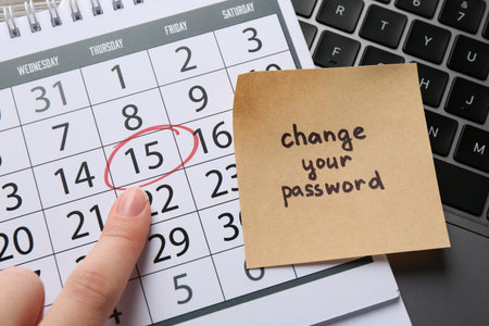 Woman with note with phrase Change Your Password, calendar and laptop at table, top viewの写真素材