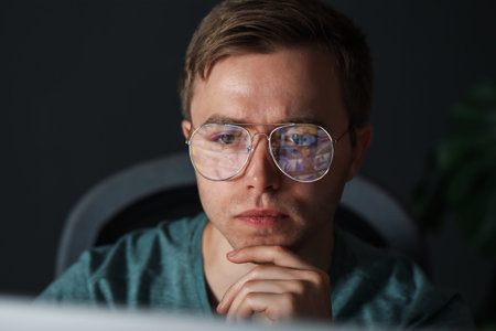 Young man wearing glasses with reflection on gray background