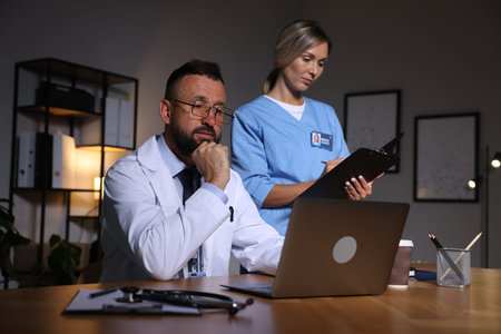 Doctor and medical assistant working in clinic during night shift