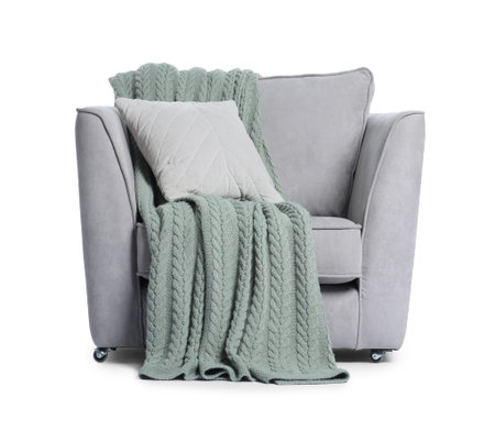 Comfortable armchair with pillow and blanket on white backgroundの写真素材