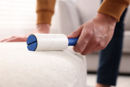 Person cleaning furniture with lint roller, closeupの写真素材