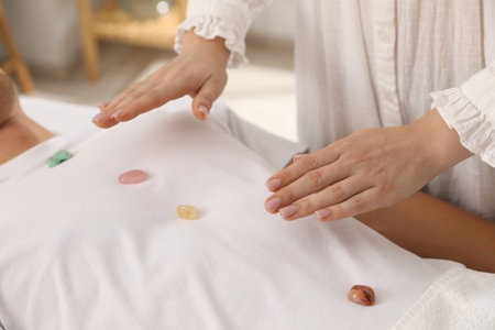 Man undergoing crystal therapy to heal or restore his aura indoors, closeupの写真素材