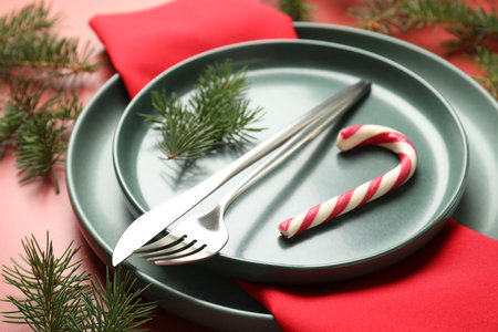 Christmas setting with plates, cutlery and fir tree branches on red background, closeupの写真素材