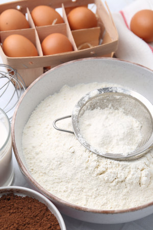 Ingredients for dough and strainer on white table, closeupの写真素材