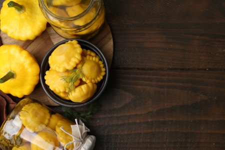 Fresh and pickled pattypan squashes on wooden table, flat lay. Space for textの写真素材