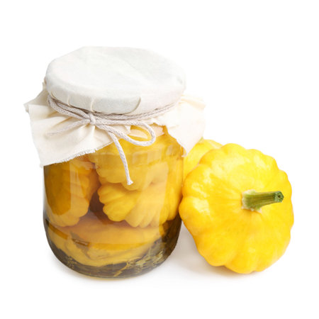 Pickled pattypan squashes in glass jar and fresh vegetables isolated on whiteの写真素材