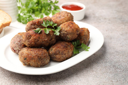 Tasty meat patties served on gray table, closeup
