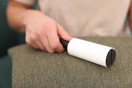 Person cleaning pillow with lint roller, closeupの写真素材