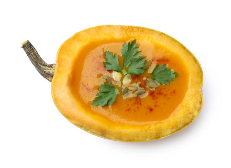 Tasty pumpkin cream soup with seeds and parsley isolated on white, top viewの写真素材