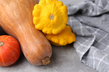 Fresh pumpkins and pattypan squashes on light gray textured table, closeup with space for text. Gourd familyの写真素材