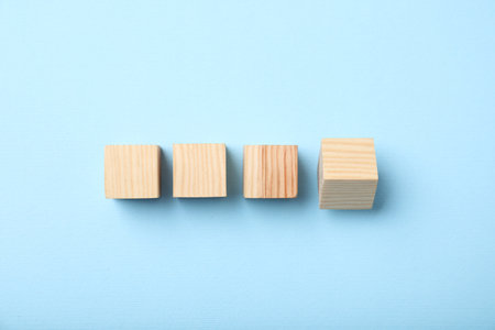 Wooden cubes on light blue background, top viewの写真素材