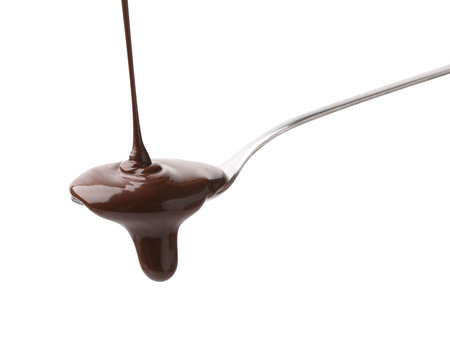 Tasty melted chocolate flowing down from spoon on white backgroundの写真素材