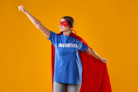 Volunteer wearing superhero costume on yellow backgroundの写真素材