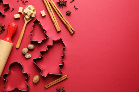 Cookie cutters and ingredients on red background, flat lay with space for text.の写真素材