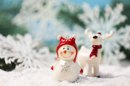 Cute decorative snowman on artificial snow against blurred background, closeupの写真素材