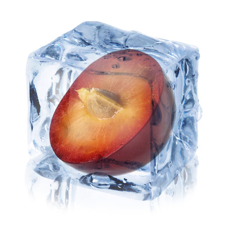 Half of plum inside ice cube isolated on whiteの写真素材