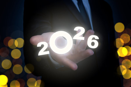 New 2026 Year. Businessman holding virtual numbers in hand against black background, closeup. Bokeh...