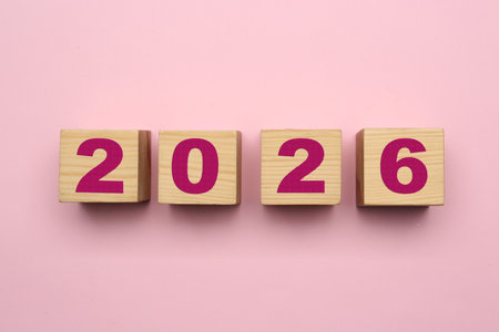 Wooden cubes with numbers on pink background, top viewの写真素材