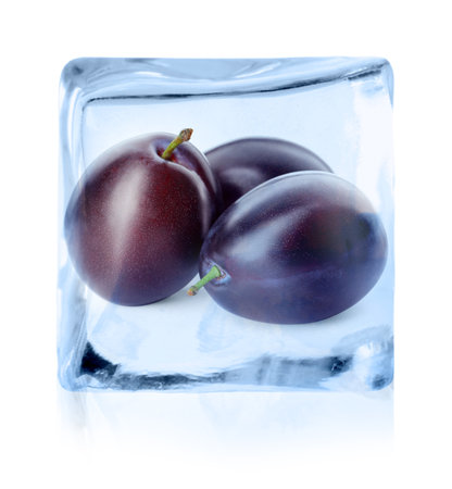 Fresh plums inside ice cube isolated on whiteの写真素材